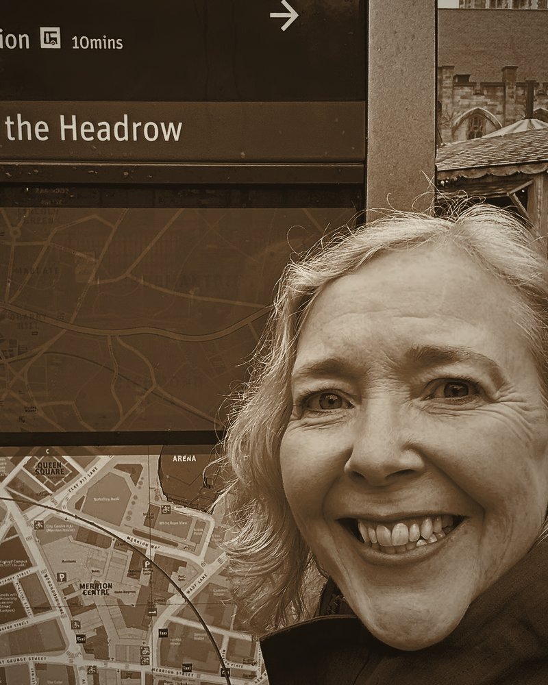 Dr Colette Jeffrey, founder of Copper Jetty, beside a Leeds wayfinding sign.